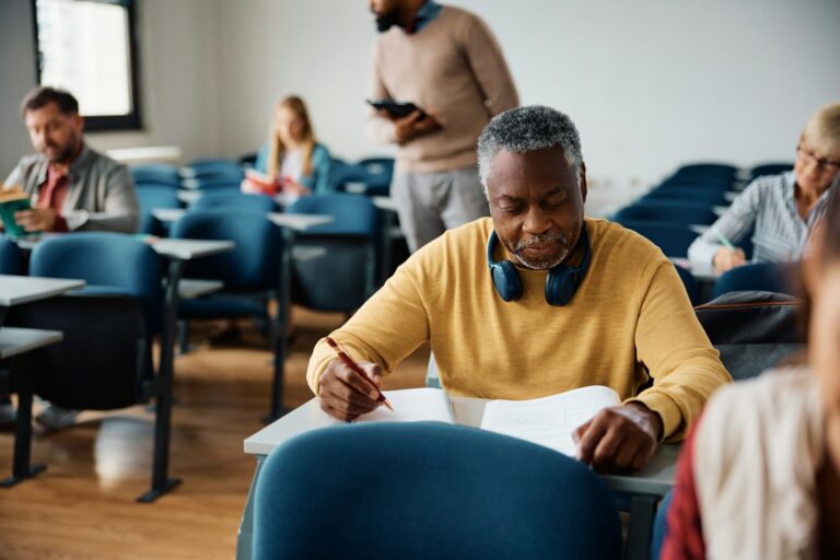 Senior black man attending educational course in the classroom.